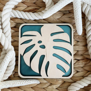 Monstera Leaf Decor Coaster displayed in a wicker basket with rope and starfish.